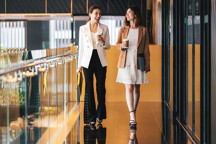 Two asian business women walking and talking