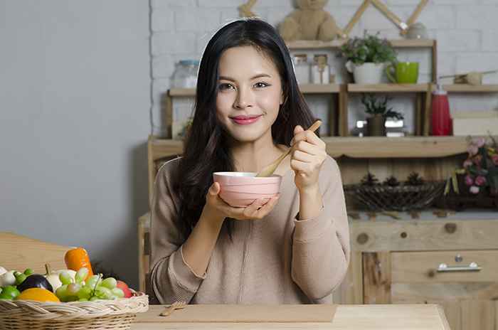 A woman holding a bowl of soup