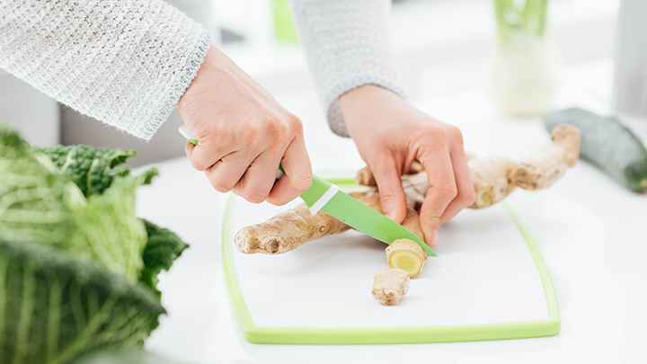 Woman slicing a piece of ginger 
