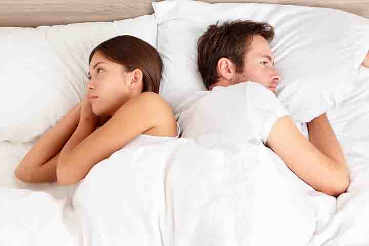Man and woman not facing each other in a bed