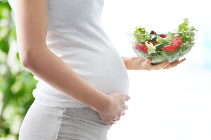 Pregnant woman with a bowl of vegetables