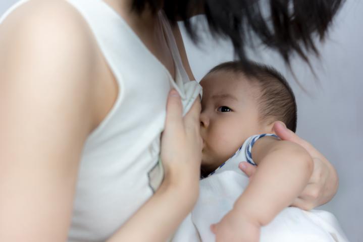 A slim and slender asian mother breastfeeds her baby