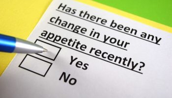A blue pen tip on a ‘Yes’ or ‘No’ questionnaire