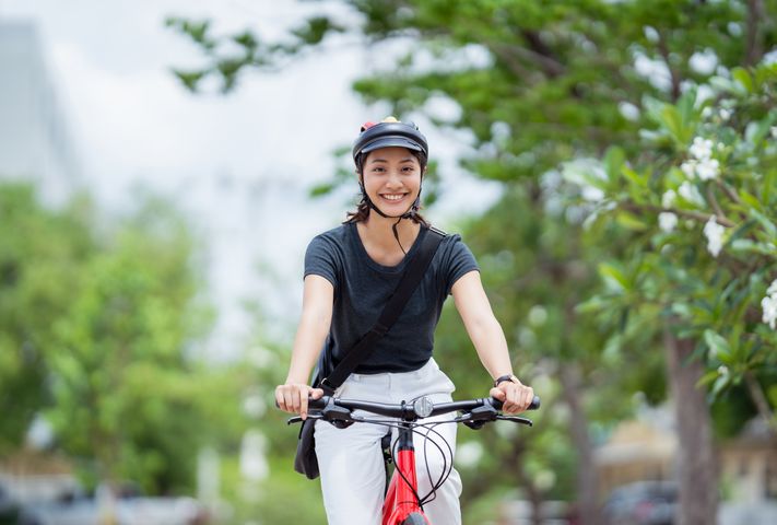 Woman smiling as she cycles a bicycle outdoors