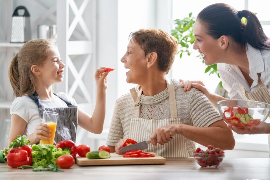 A girl preparing a healthy meal with her grandmother and mother