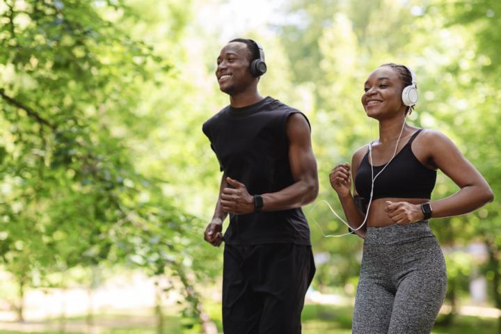A couple is jogging leisurely in the park wearing black and grey athleisure