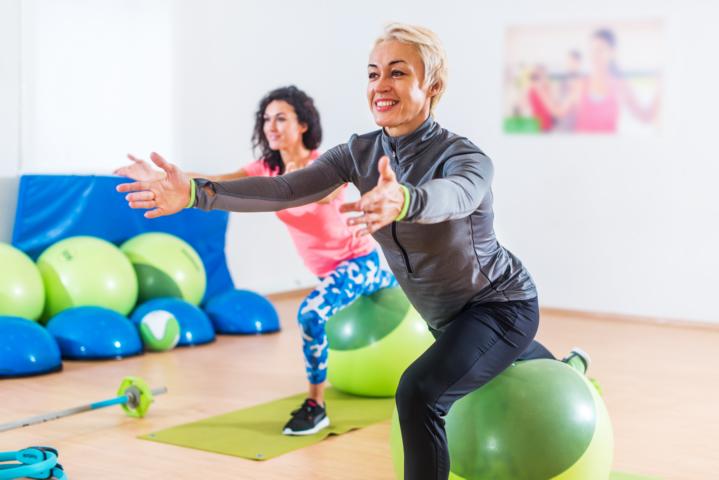 A group of women are doing aerobic workout with yoga balls